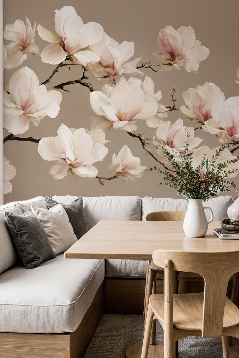 Coin repas avec banquette et table en bois clair devant un papier peint magnolias