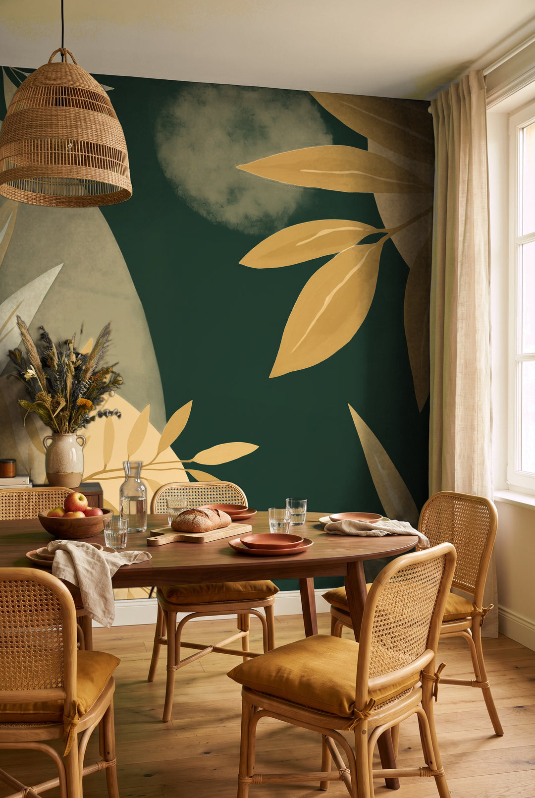 Salle à manger avec table en noyer et chaises cannées devant un papier peint panoramique de feuillages ocre sur fond vert forêt