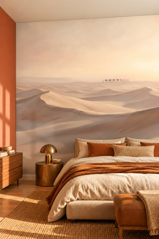 Chambre avec mur terracotta et lampe en laiton devant un papier peint panoramique de dunes du désert