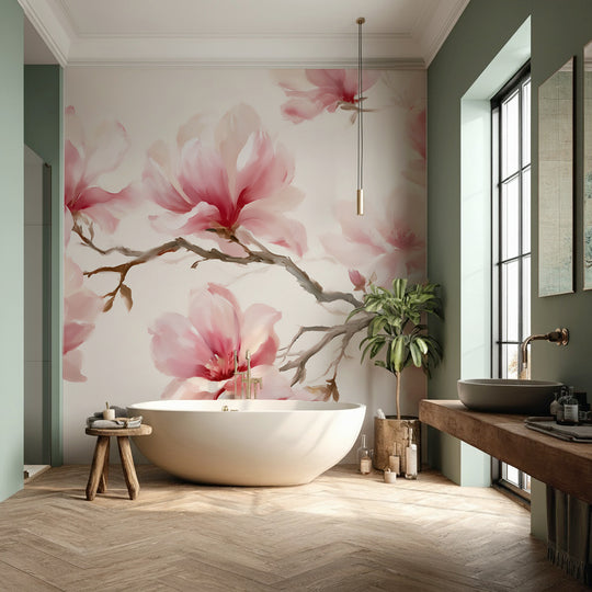 Salle de bain avec baignoire îlot et murs vert sauge devant un papier peint panoramique de magnolias roses
